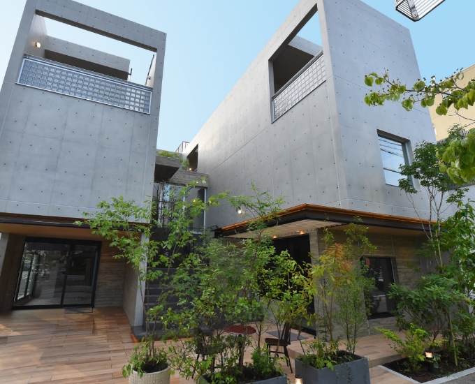 施工事例：植栽の中庭を囲むコンクリート打ち放しの建物